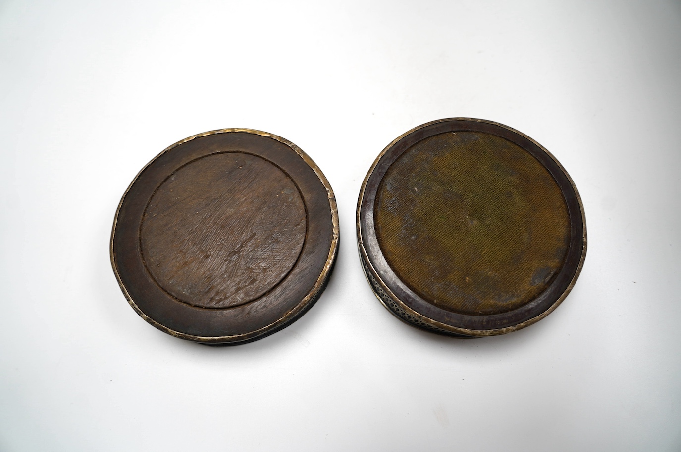 A pair of George III silver mounted wine coasters, diameter 12.1cm, marks rubbed, possibly Robert Hennell, London, 1792. Condition - poor